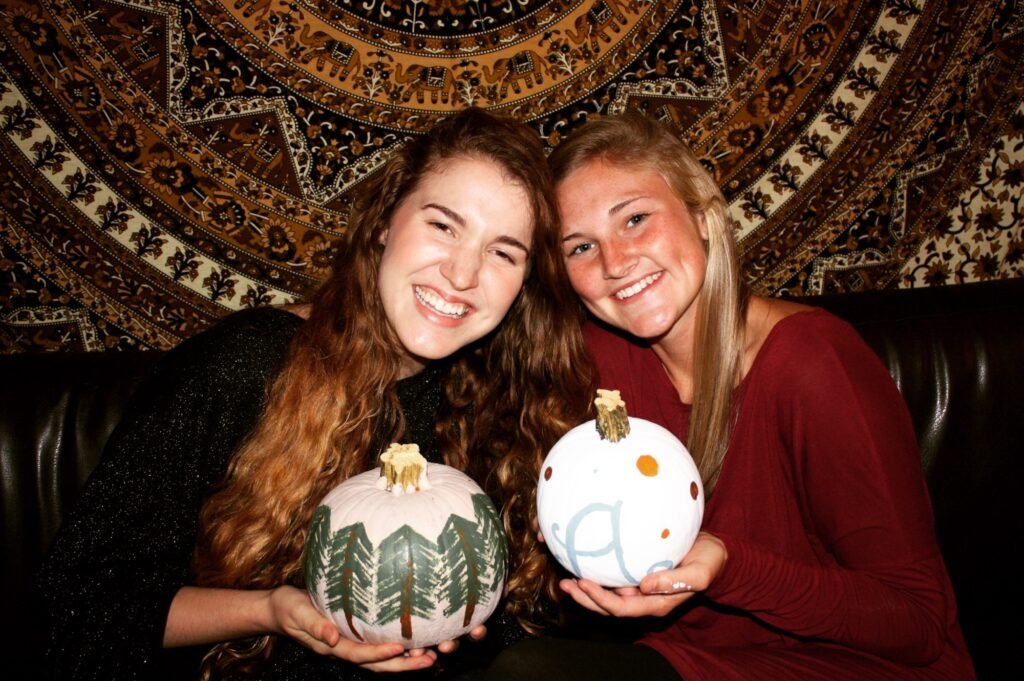 Abigail and friend painting pumpkins as an example for fun fall family activities