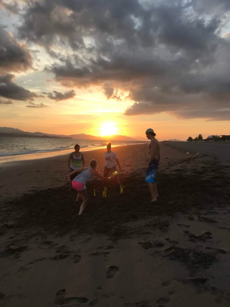 Abigail and friends playing spikeball on the beach as an example of tech-free family activities